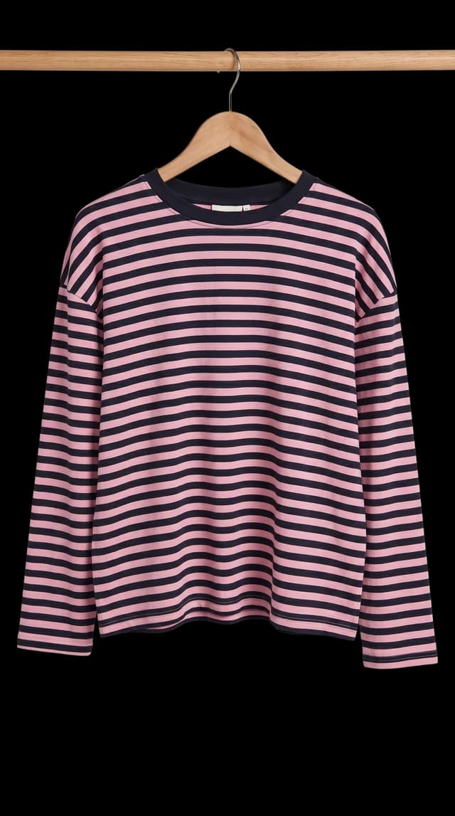 Maglia a maniche lunghe a righe rosa e nere su una gruccia